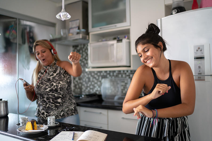 Mother and daughter having fun together while dancing in the kitchen Photograph by FG Trade