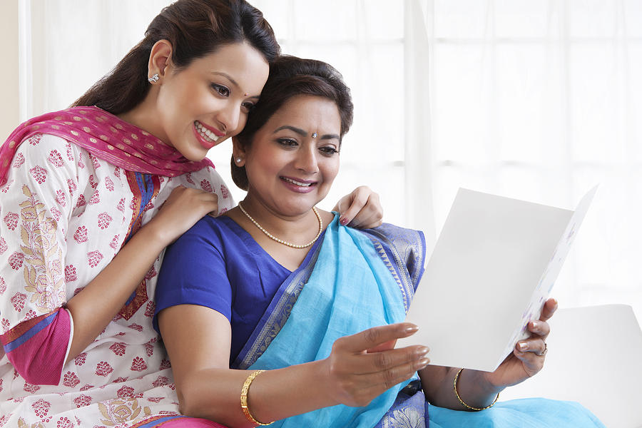Mother and daughter reading a greeting card Photograph by IndiaPix/IndiaPicture