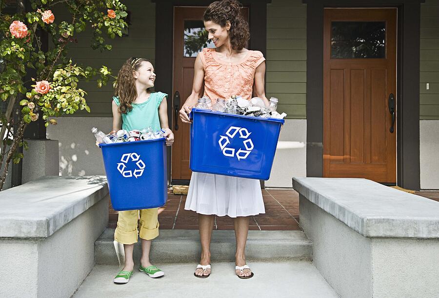 Mother and daughter recycling Photograph by Jupiterimages