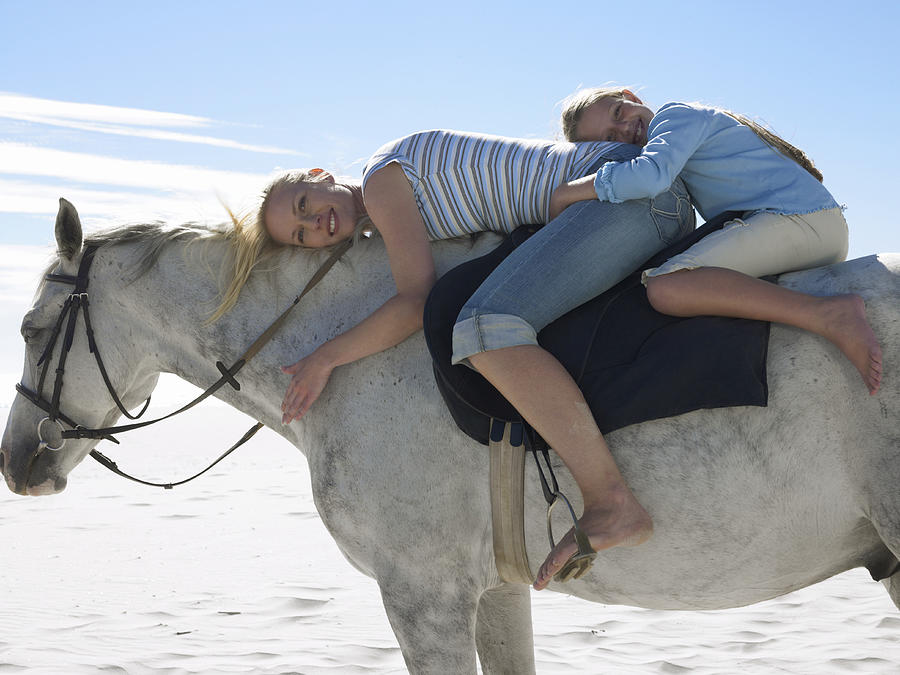 Mother and Daughter Riding a White Horse Photograph by Digital Vision.