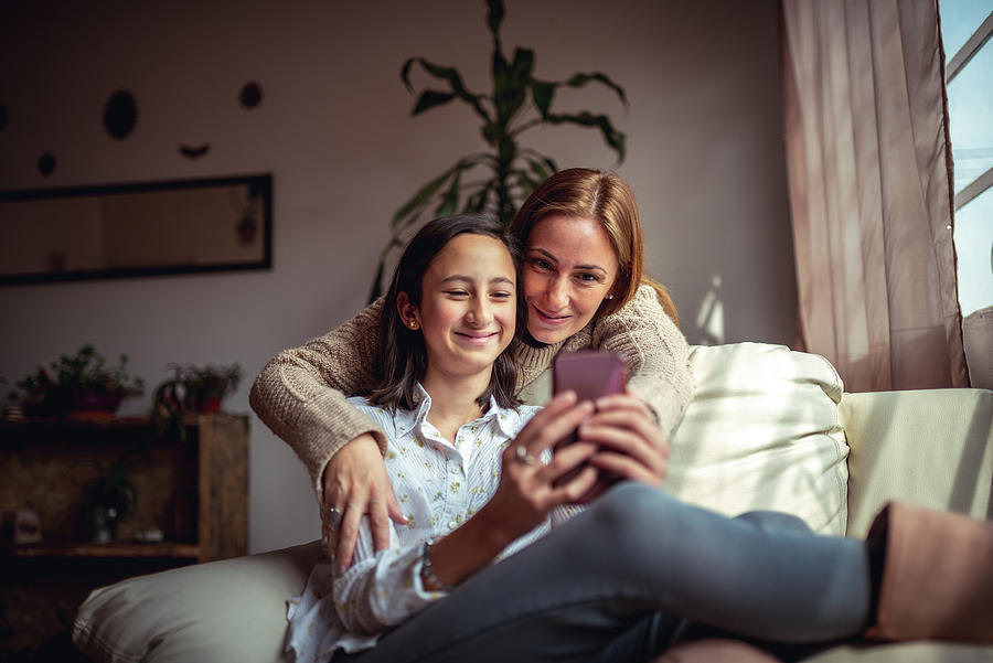 Mother and daughter using a smartphone Photograph by MStudioImages