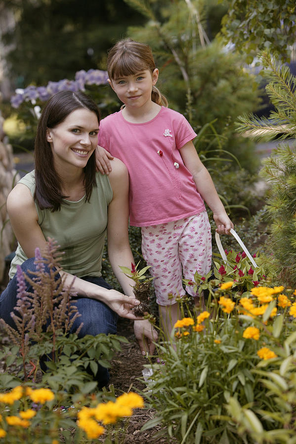 Mother and daughter working in garden Photograph by Comstock