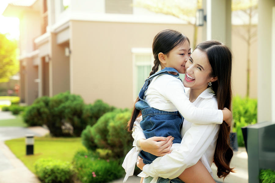 Mother and her daughter play togater in home garden with sunrise ...