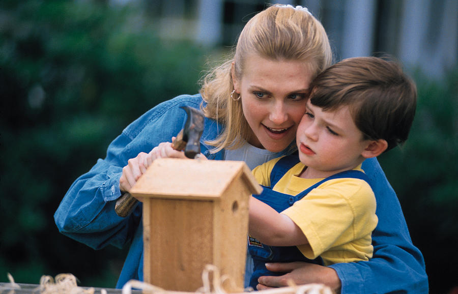 Mother and son building a birdhouse Photograph by Comstock