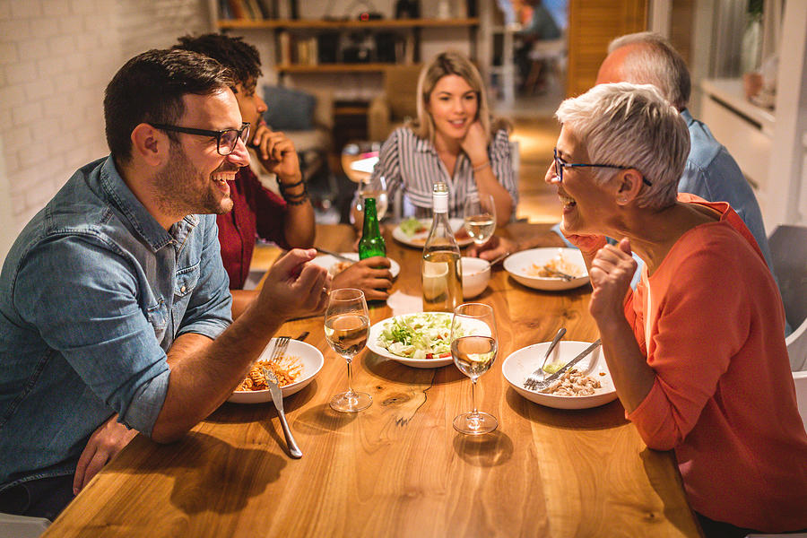Mother and son chatting during dinner party Photograph by FluxFactory