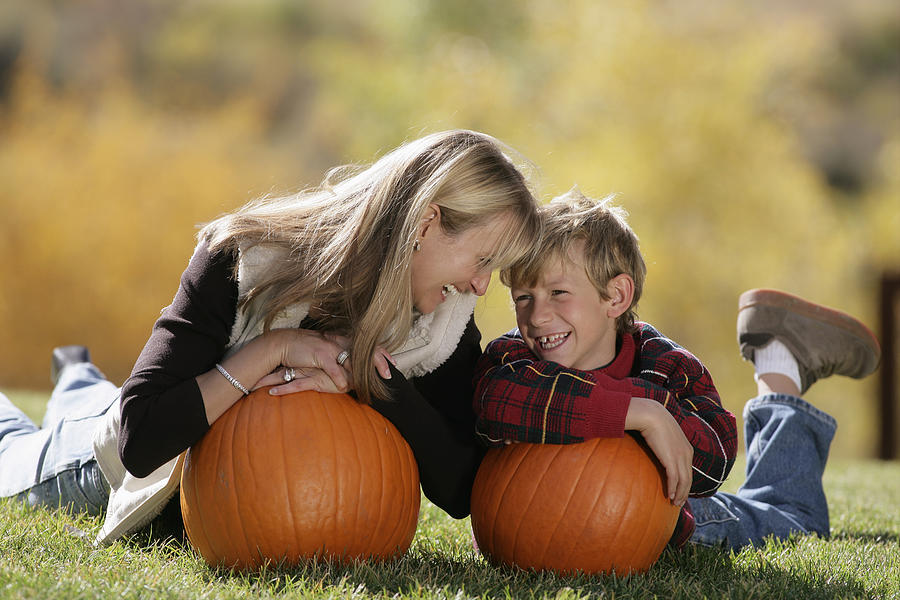 Mother and son holding pumpkins Photograph by Comstock Images