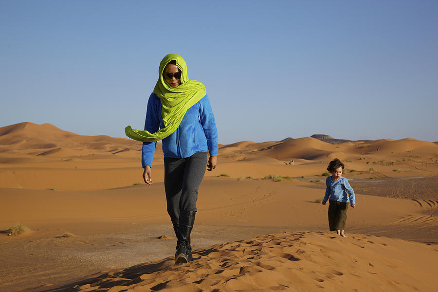 Mother and son walking in desert Photograph by Mike Tauber