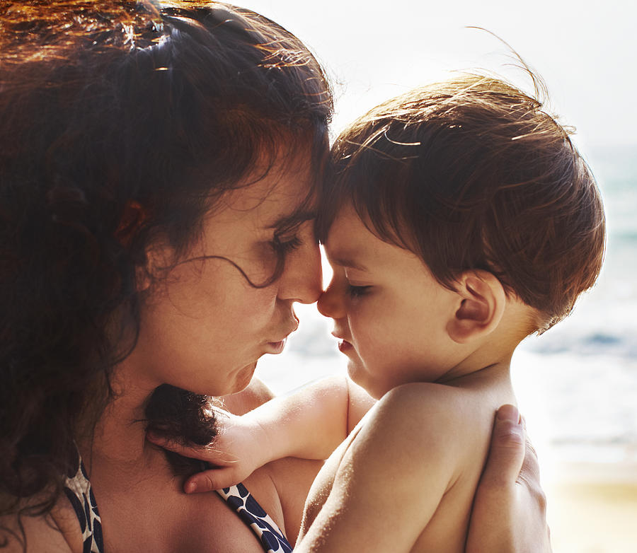 Mother and toddler kissing on beach Photograph by Niels Busch