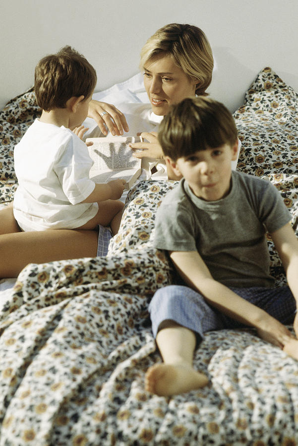 Mother and two children lazing around in bed Photograph by PhotoAlto/Michel Bussy