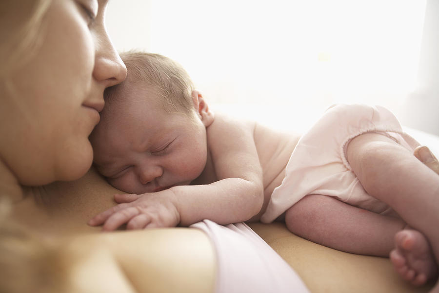 Mother cradling newborn infant Photograph by Nick Stevens