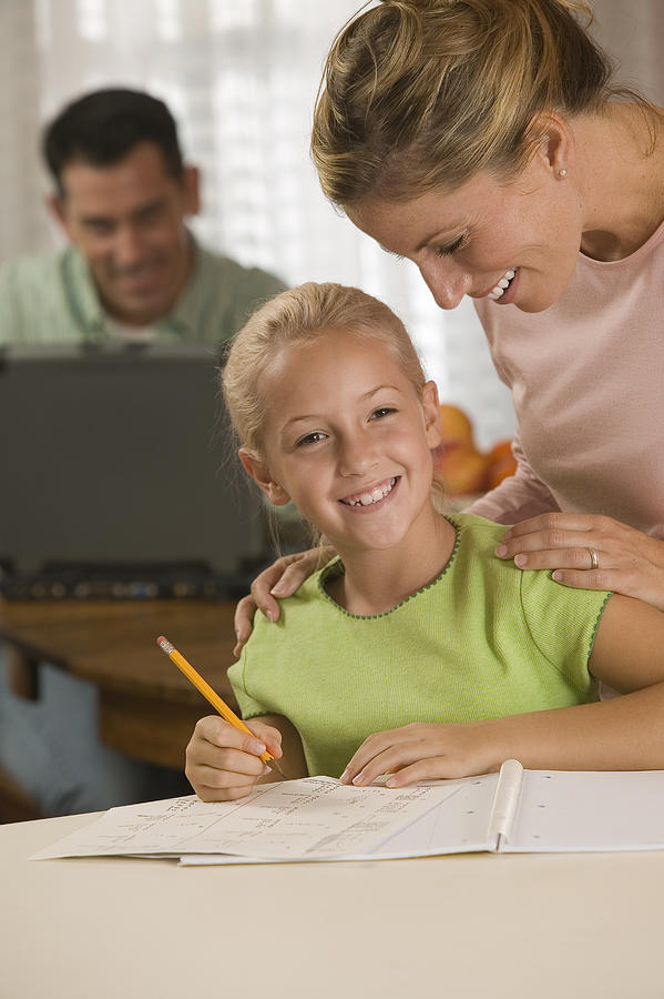 Mother helping daughter with homework Photograph by Comstock Images