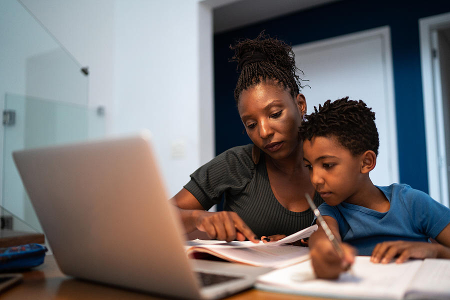Mother helping son with homework at home Photograph by FG Trade Mother helping son with homework at home Photograph by FG Trade
