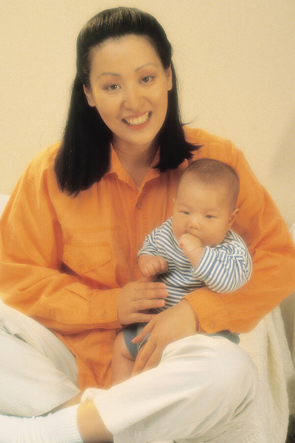 Mother holding baby in lap Photograph by Comstock