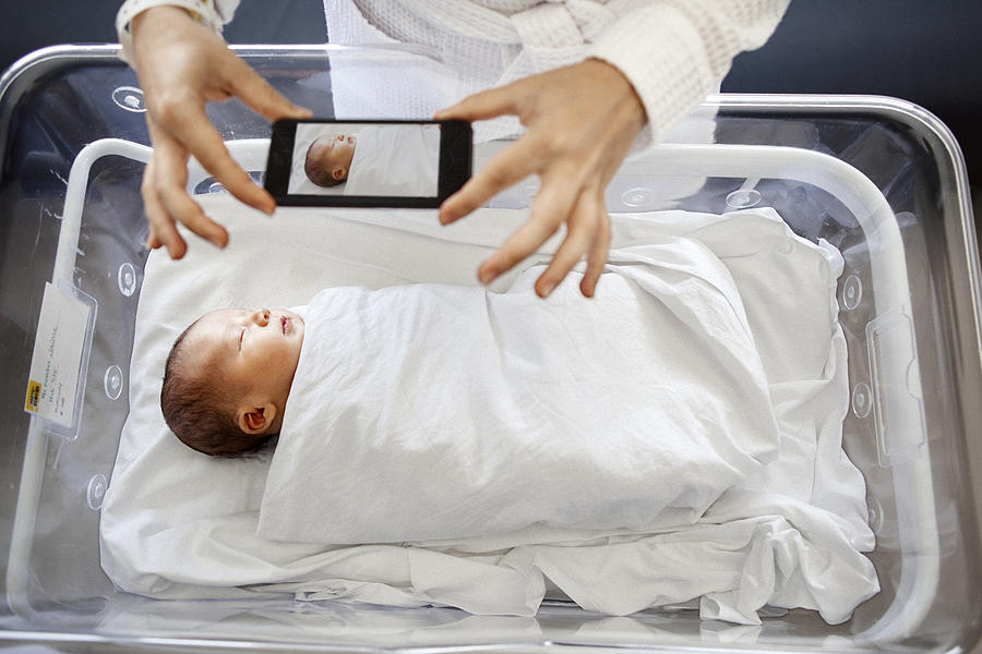 Mother photographing newborn son Photograph by Orbon Alija