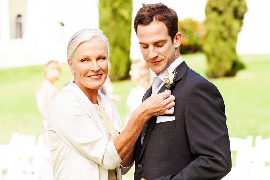 Mother Pinning Corsage On Grooms Suit At Outdoor Wedding Photograph by Neustockimages