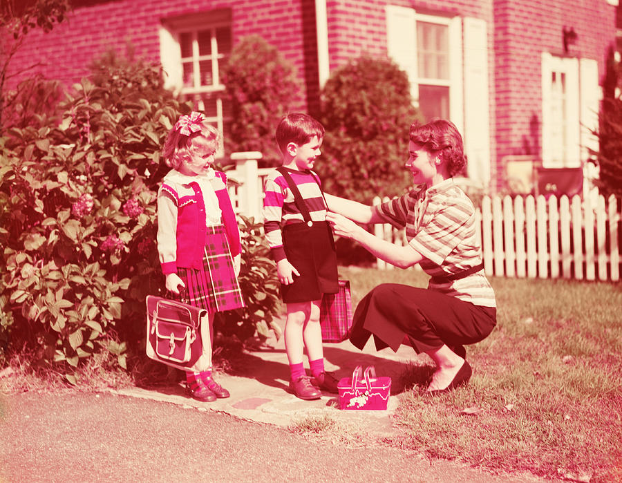 Mother preparing daughter and son to go to school with lunch boxes, books and bags. (Photo by H. Armstrong Roberts/Retrofile/Getty Images) Photograph by H. Armstrong Roberts