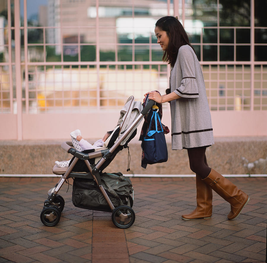 Mother pushing baby in stroller Photograph by images by Tang Ming Tung