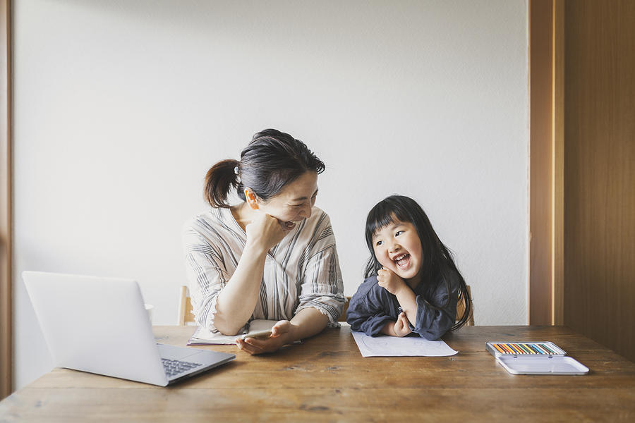 Mother working from home with daughter Photograph by Kohei_hara