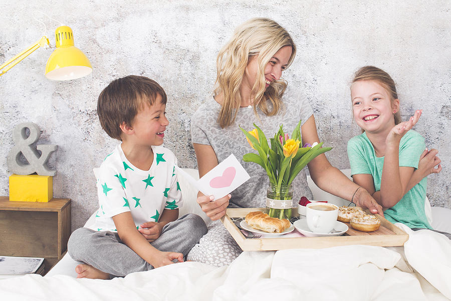 Mother´s Day - two children surprise their mother with breakfast in modern bed Photograph by Epiximages