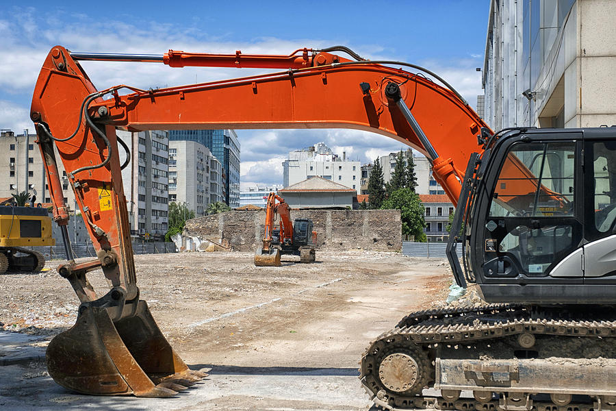 Motinless excavators on a sunny day standing in a construction site . Photograph by Emreturanphoto