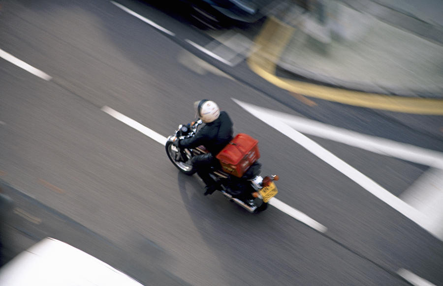 Motorcycle courier or Pizza delivery speeding Photograph by Andrew Holt