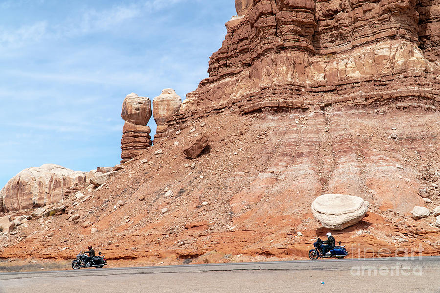 Motorcyclists cruise beneath the Twin Rocks or Navajo Twins rock Photograph by William Kuta