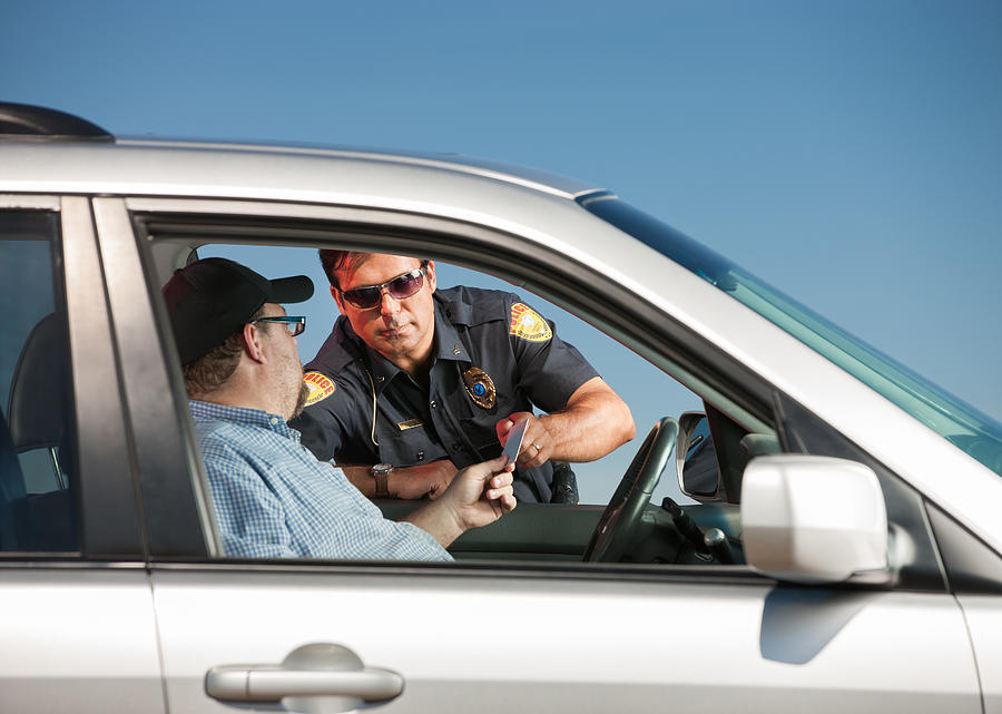 Motorist Handing Police Officer His License Photograph by Avid_creative