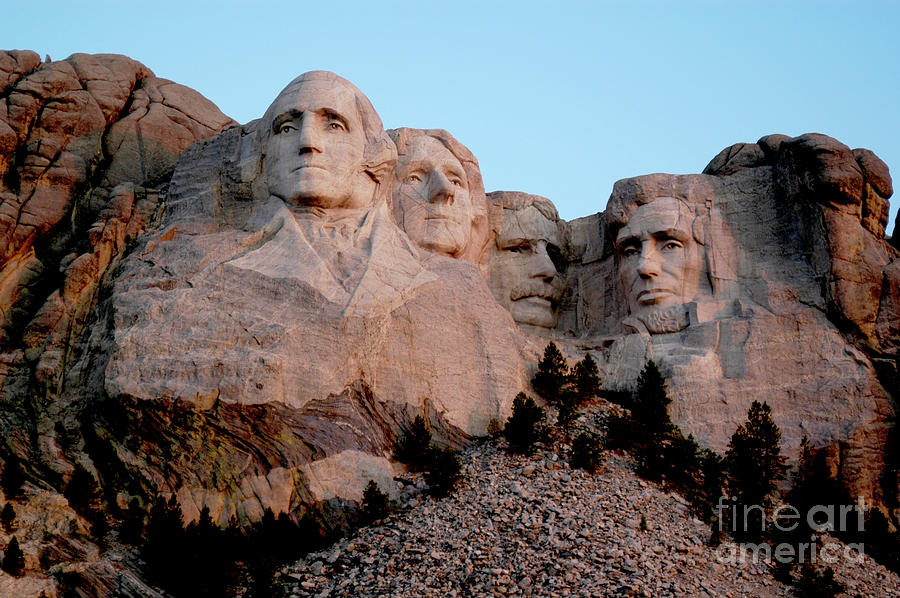 Mount Rushmore as the morning sun begins to light up the mountain. Photograph by Gunther Allen