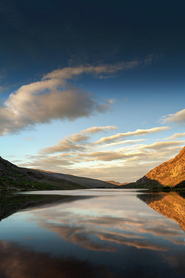 Mountains reflected into Llyn Ogwen at sunset, North Wales Photograph by Victoria Ashman