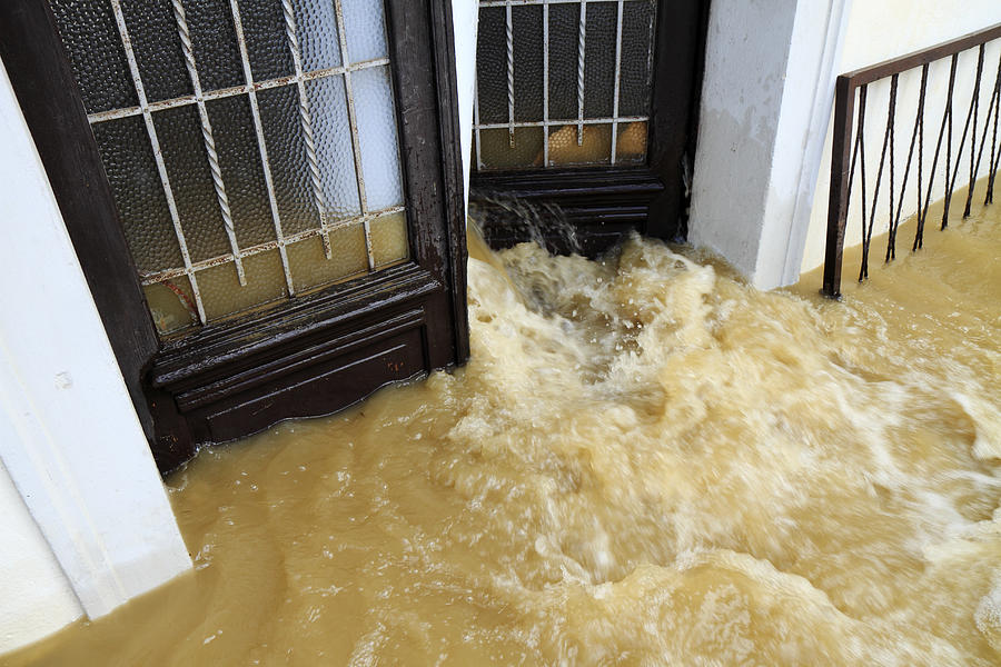 Muddy water pouring through the entrance door Photograph by BremecR