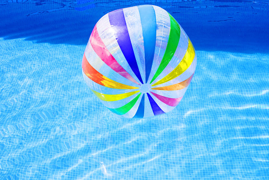 Multi coloured beach ball in swimming pool Photograph by Lyn Holly Coorg