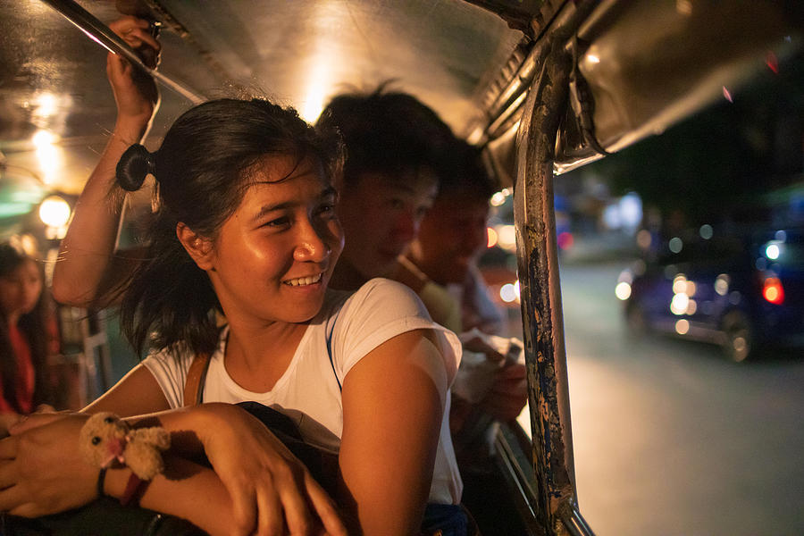 Multi-Ethnic Asian friends riding jeepney in Manila at night Photograph by Satoshi-K