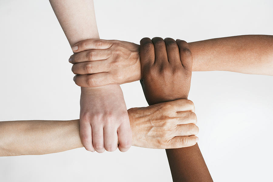 Multi-ethnic women holding wrists Photograph by Jon Feingersh Photography Inc