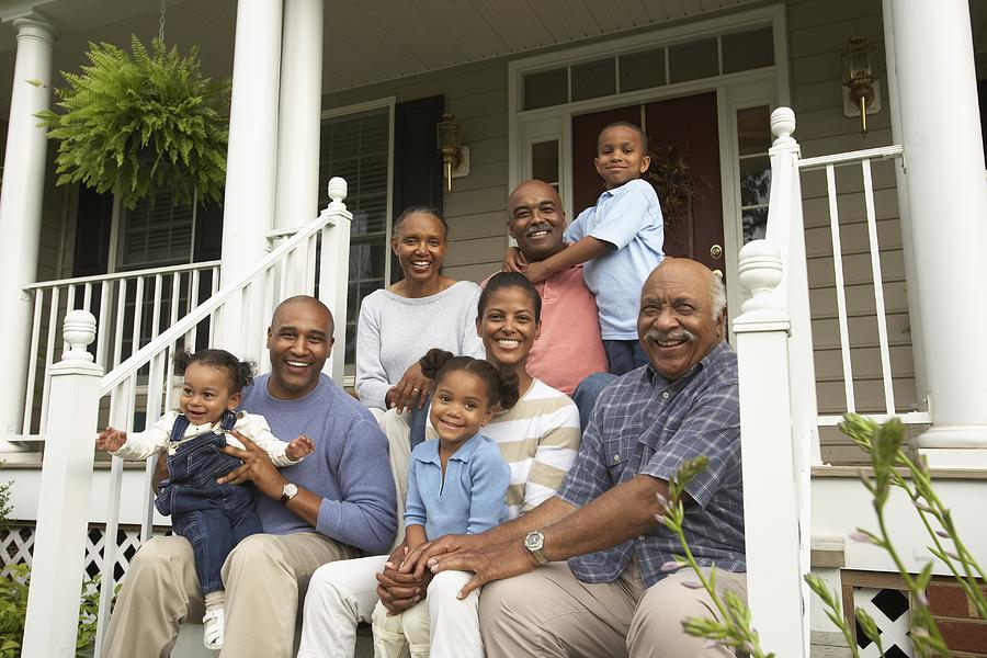 Multi-generational African family smiling on porch Photograph by Ariel Skelley