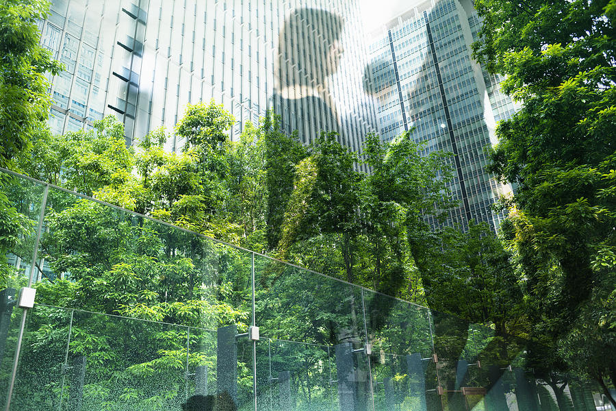 Multi layered, businesswomen walking in city with green Photograph by Hiroshi Watanabe
