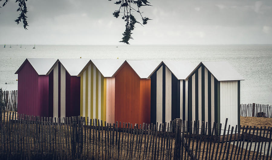Multicolored beach cabins and grey sky  Photograph by Jean-Luc Farges