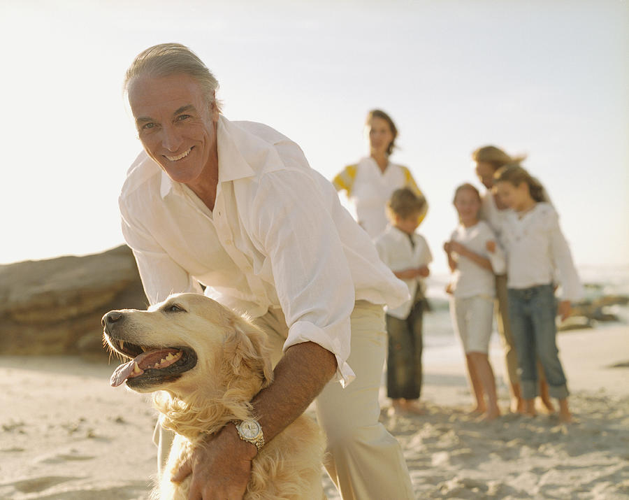 Multigenerational family at beach with dog Photograph by Sam Edwards