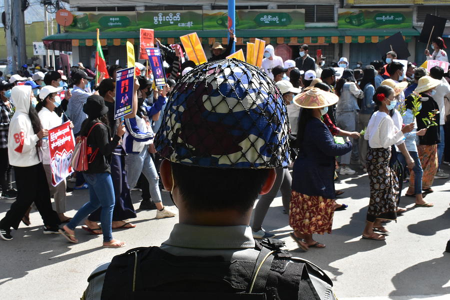 Myanmar policeman watches the protesters  Photograph by Robert Bociaga