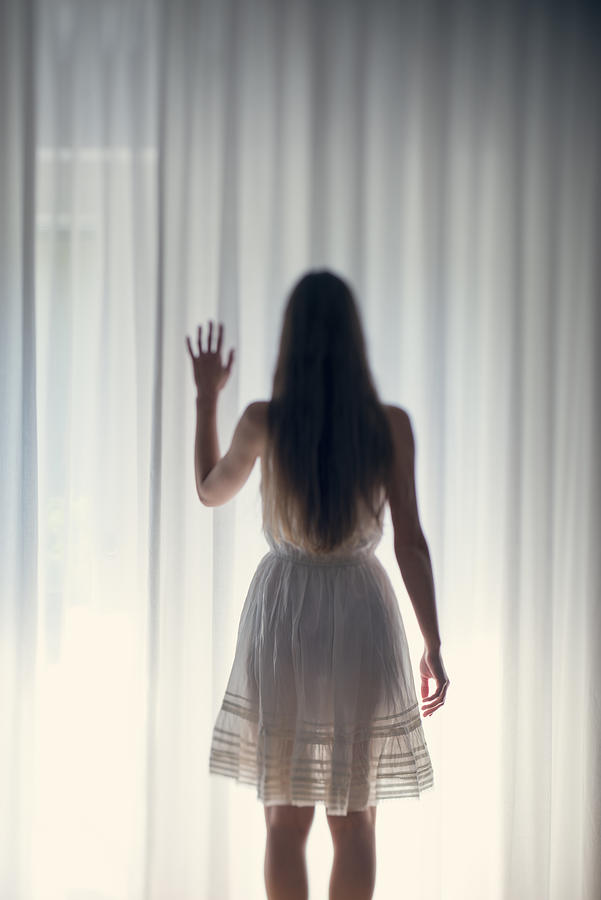 Mystical young woman standing in front of a white curtain, back view Photograph by Westend61
