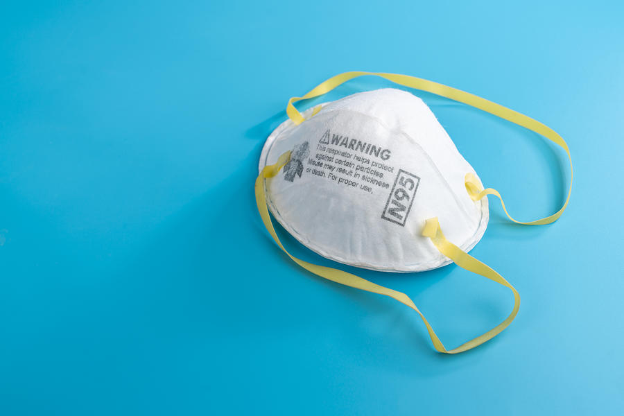 N95 Respirators and Surgical Masks (Face Masks). White medical mask isolate. Face mask protection against pollution, virus, flu and coronavirus. Health care and surgical concept. Photograph by Naruecha Jenthaisong