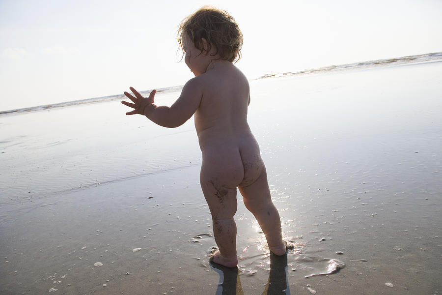Naked baby girl (9-12 months) playing at beach Photograph by Marc Romanelli