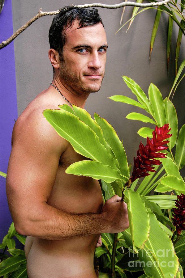 Naked hot man hides behind a big red flower.   Photograph by Gunther Allen