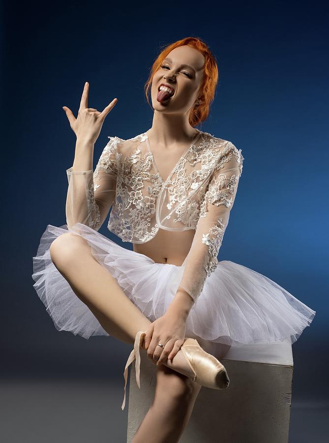 Naughty Ballerina Showing Tongue And Horn Gesture In Blue Studio