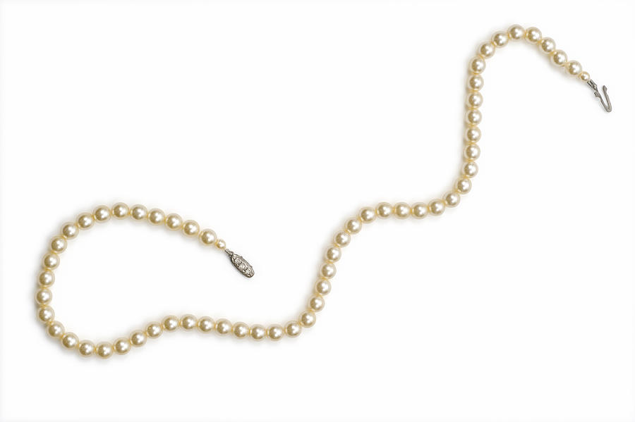 Necklace made with small pearls over a white background Photograph by MarkSwallow