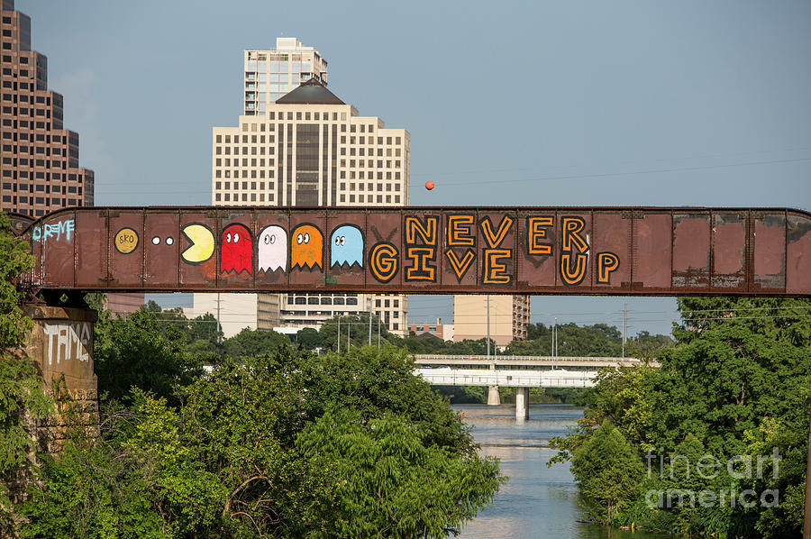 Austin Photograph - Never Give Up is a mural painting on the Austin Railroad Graffiti Bridge over Lady Bird Lake by Dan Herron