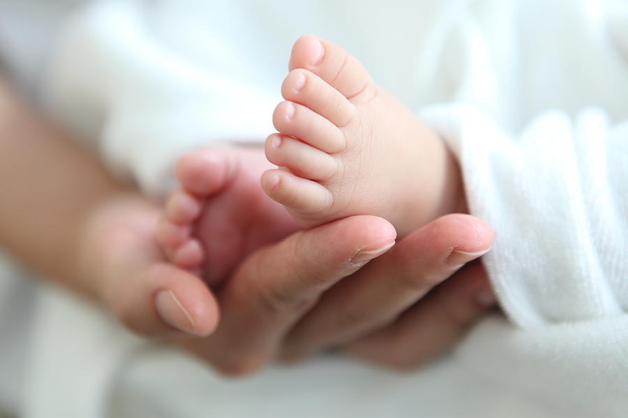 Newborn babys feet in parent hand Photograph by Wild Horse Photography