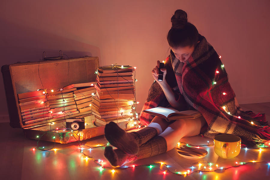 Night exciting reading with christmas lights Photograph by Rasstock