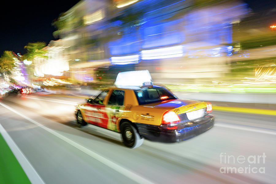 New York City Photograph - Night photo of a taxi cab speeding through the streets of Miami Beach by Felix Mizioznikov