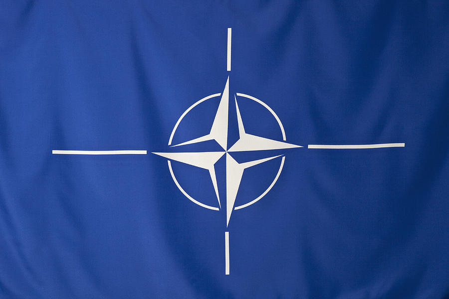 North Atlantic Treaty Organization flag, white compass rose emblem in blue background Photograph by Caspar Benson