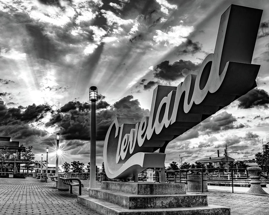 North Coast Harbor Sunrise Beyond The Cleveland Script Sign - Black and White Photograph by Gregory Ballos